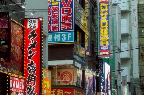 Bustling night scene in Akihabara, Tokyo, showcasing vibrant signage and lively crowd.