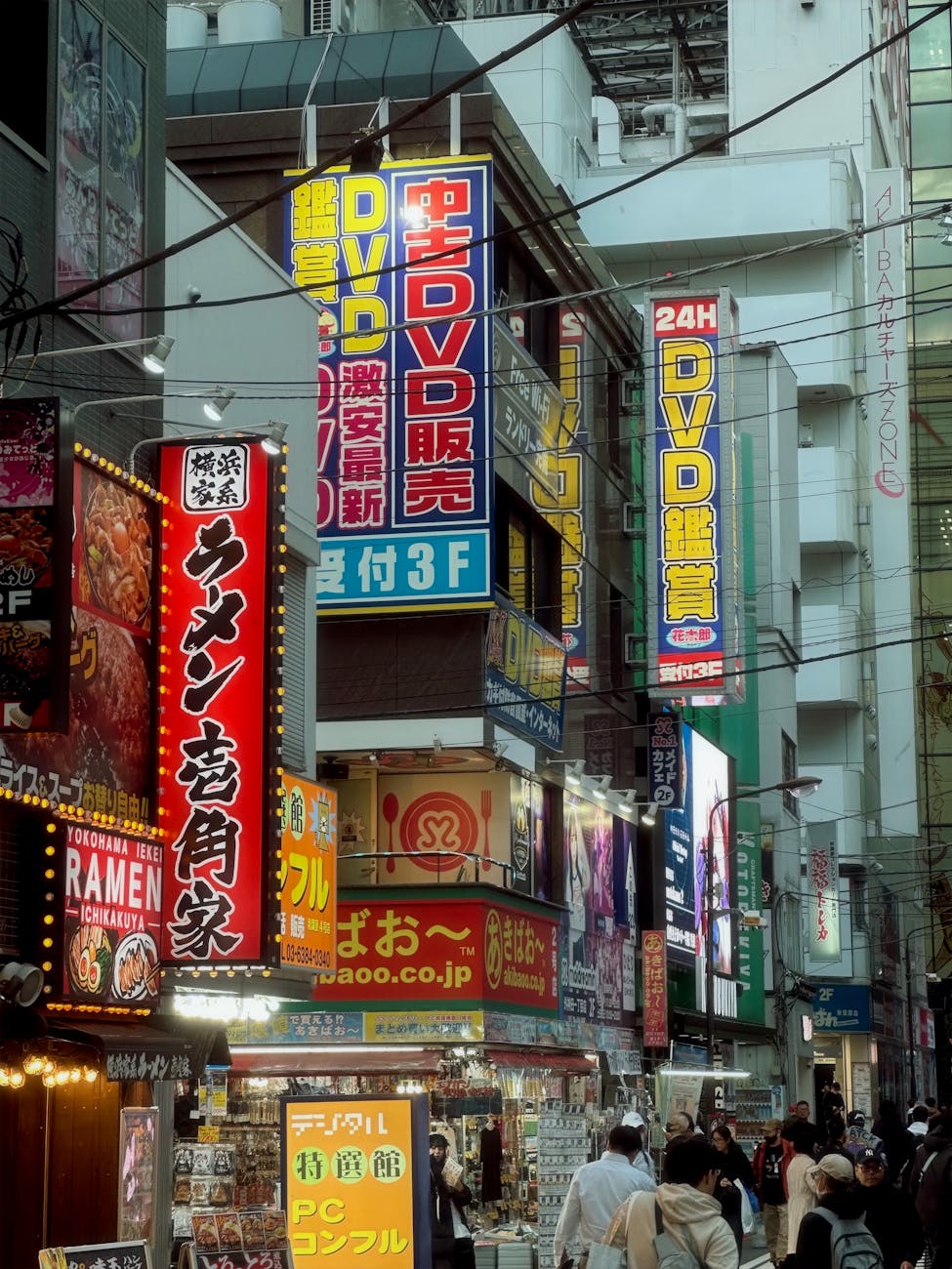 Bustling night scene in Akihabara, Tokyo, showcasing vibrant signage and lively crowd.