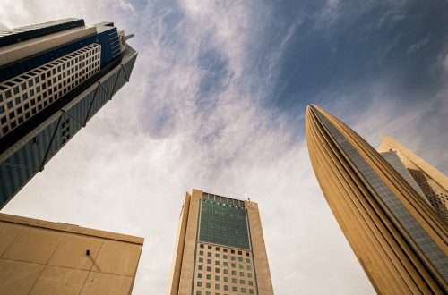 A stunning view of Kuwait City's modern architecture with prominent skyscrapers set against a dramatic sky.