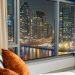 An elegant view of Dubai Marina's night skyline through a luxurious hotel window.