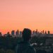 A person admires the Melbourne skyline at sunset, creating a stunning silhouette against a vibrant sky.