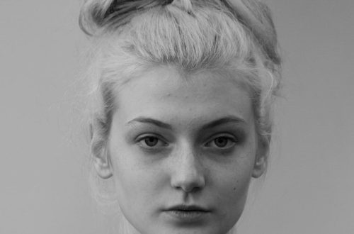 Captivating black and white portrait of a young woman with natural hair.