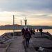 People walking on a jetty during sunset in Istanbul, creating a serene coastal landscape.