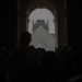 Silhouettes of people in front of the iconic Louvre Pyramid in Paris, France.