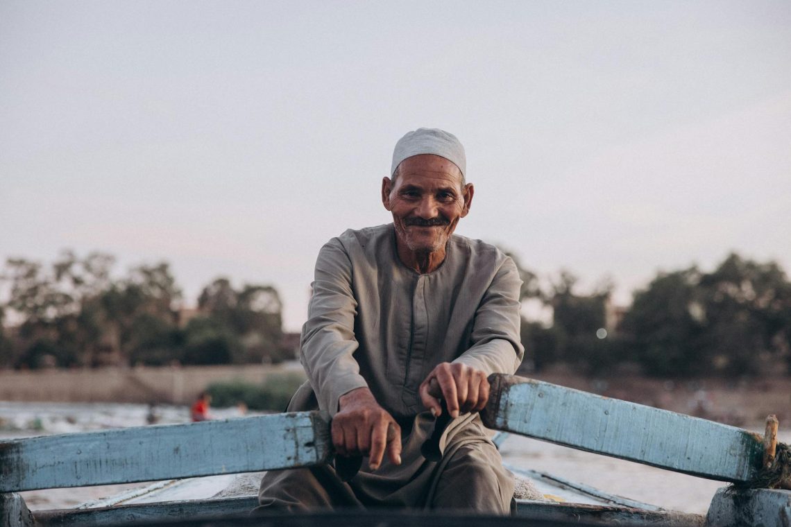 Elderly man enjoying a serene boat ride on the Nile in Al Qanatir, Egypt.