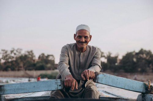 Elderly man enjoying a serene boat ride on the Nile in Al Qanatir, Egypt.