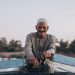 Elderly man enjoying a serene boat ride on the Nile in Al Qanatir, Egypt.