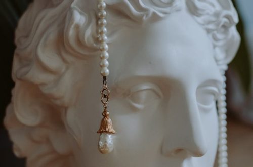 An elegant sculpture adorned with pearls, showcasing classical art and jewelry fusion.