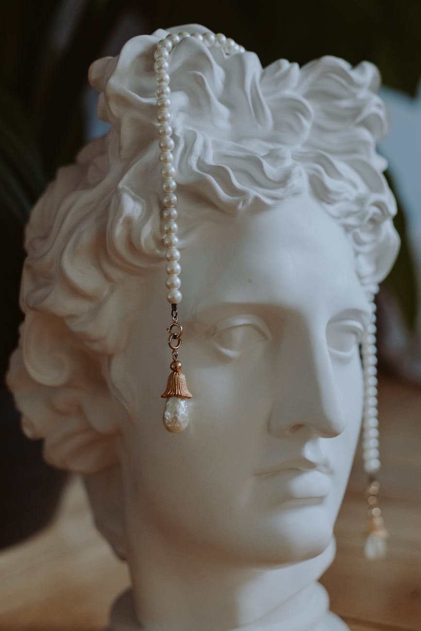 An elegant sculpture adorned with pearls, showcasing classical art and jewelry fusion.