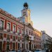 View of the iconic Puerta del Sol clock tower in Madrid, Spain, during dusk.