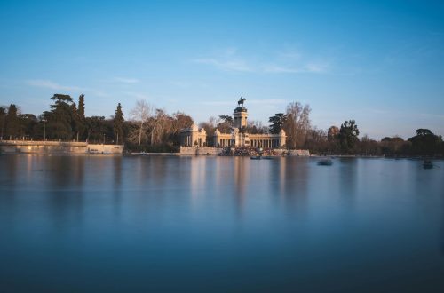 Scenic view of the lake and monument at El Retiro Park during twilight in Madrid, Spain.