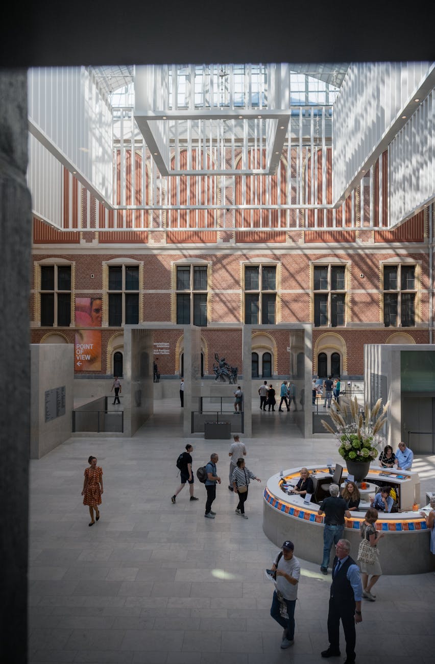 Rijksmuseum atrium in Amsterdam with people exploring a daylight indoor setting.