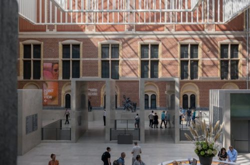 Rijksmuseum atrium in Amsterdam with people exploring a daylight indoor setting.