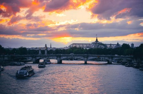 Beautiful sunset view of the Seine River and bridges in Paris with vibrant skies.