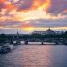 Beautiful sunset view of the Seine River and bridges in Paris with vibrant skies.
