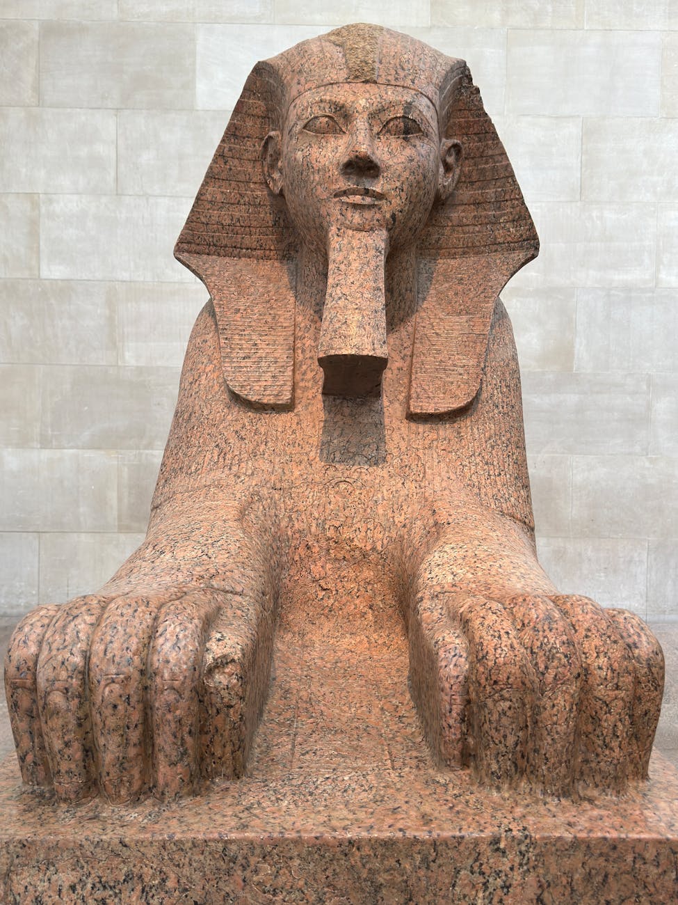 Granite Sphinx statue showcasing ancient Egyptian art in museum.