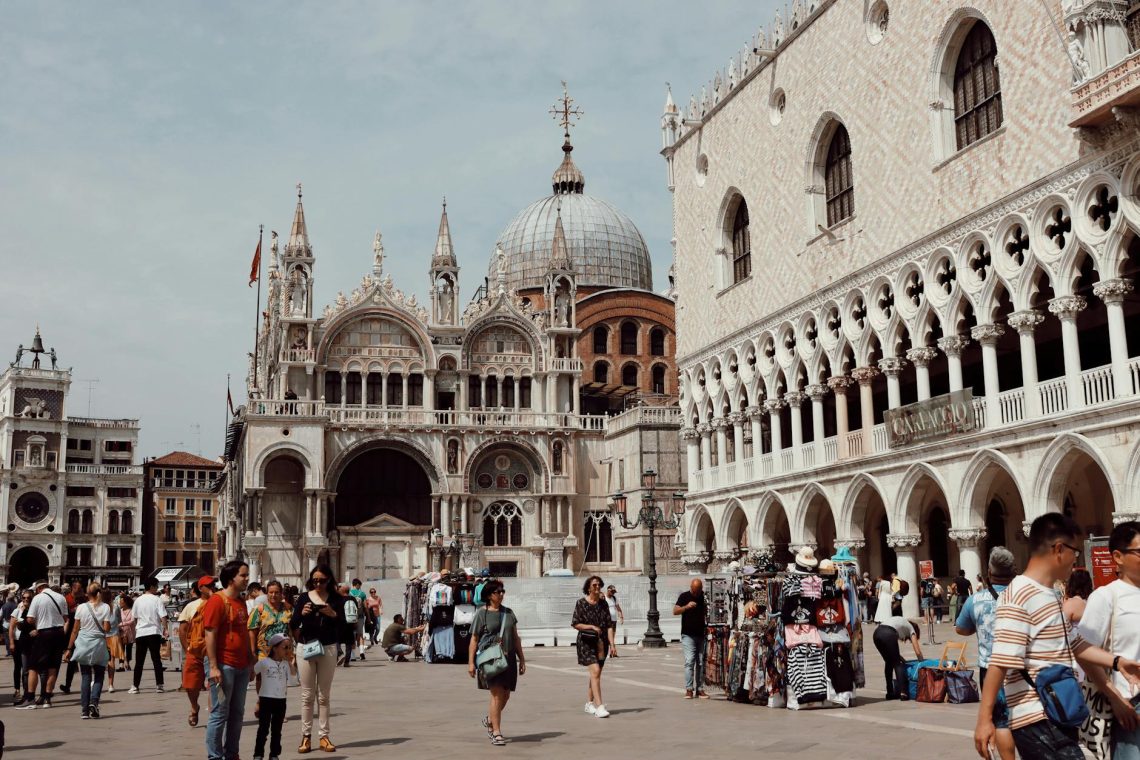 Visitors explore the iconic Piazza San Marco with St. Mark's Basilica in Venice, Italy.