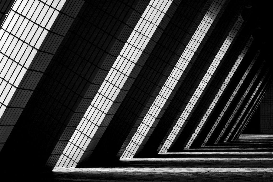 Dynamic black and white photo of modern architectural columns in Hong Kong.