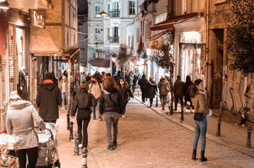 Evening in Istanbul with people strolling through a lively street lit by warm lights.