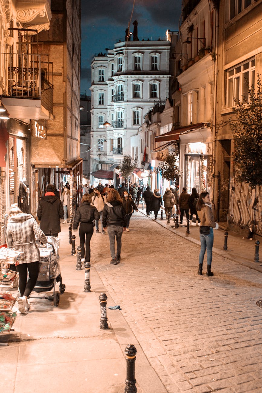 Evening in Istanbul with people strolling through a lively street lit by warm lights.