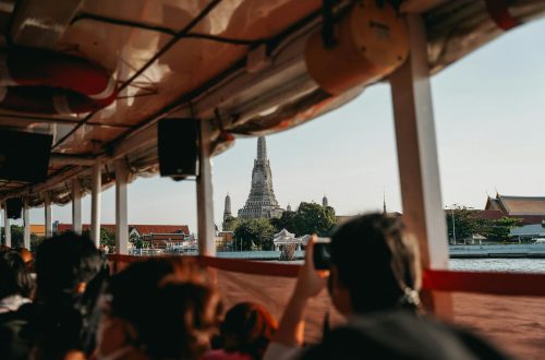 A scenic view of Wat Arun temple from a riverboat in Bangkok, capturing the essence of Thai culture.